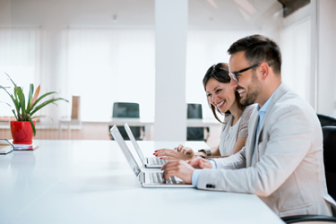 GettyImages-931182764 Cheerful Office Workers On Laptops GettyImages-931182764 Cheerful Office Workers On Laptops