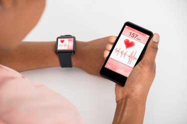Hand With Mobile And Smartwatch Showing Heartbeat Rate GettyImages-609624686