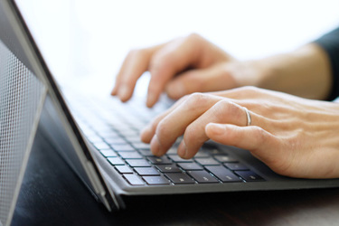 Asian man typing on laptop-GettyImages-1371907414