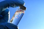 glass vial containing water and micro plastic pieces of pollution-GettyImages-2191203025