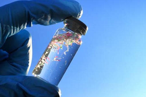 glass vial containing water and micro plastic pieces of pollution-GettyImages-2191203025