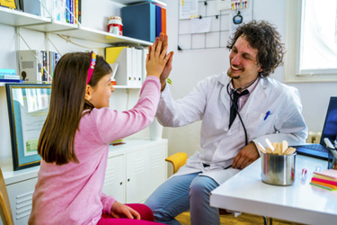 doctor high fives young patient-GettyImages-1370189681