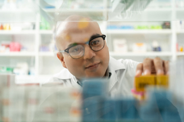 pharmacist checks inventory, drug shelves-GettyImages-1941443650