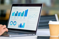 GettyImages-2160140672-dashboard-laptop-data-charts-hand-coffee-cup