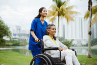 Malaysia - care worker with patient in a wheelchair (high res)