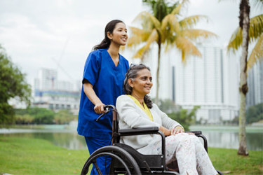 Malaysia - care worker with patient in a wheelchair (high res)