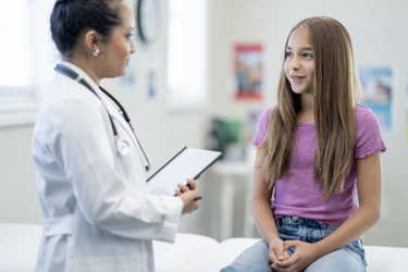 Doctor communicating with teenage patient-GettyImages-2221879508