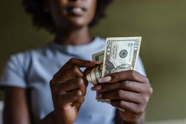 GettyImages-1414279526 woman holding money