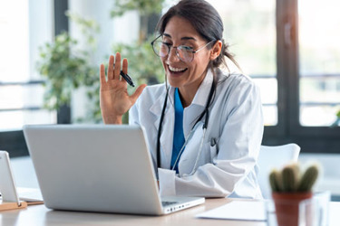 female doctor waving and talking with colleagues iStock-1249601252