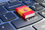 Spanish language textbook on laptop keyboard-GettyImages-1847119366