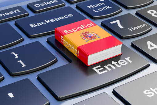 Spanish language textbook on laptop keyboard-GettyImages-1847119366