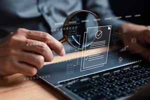 GettyImages-1465316262-computer-magnifying-glass-audit-documents
