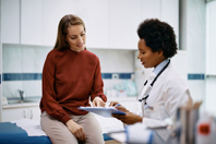 patient and doctor analyzing medical report-GettyImages-1461330630