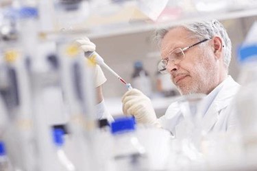 scientist researching in laboratory pipetting into test tub
