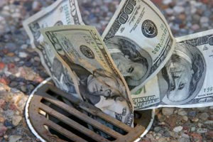 money, dollars down the drain-GettyImages-157193934