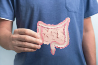 GettyImages-1348052156 Man holding paper made model intestine