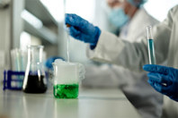 GettyImages-2113980747-laboratory-scientists-beaker-green-liquid-reaction-smoke