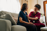Elderly woman at home with HCP using stethoscope 1 (high res)