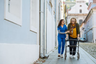 EU - elderly woman with walker and HCP on sidewalk (high res)