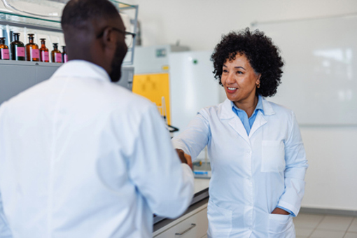 Are You Still Evaluating CMOs When You Really Need A CDMO? 2 Scientists shaking hands-GettyImages-2194013620