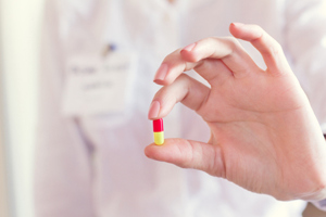Pill capsule in doctors hand-GettyImages-922565512