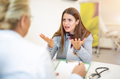 frustrated woman talking with doctor-GettyImages-1180820371