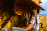 GettyImages-1327948072 Farmer repairing harvester