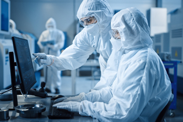 Two Cleanroom Scientists Examining Data GettyImages-1294339670