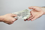Should We Pay Patients In Clinical Trials For Their Time? Two-hands-exchanging-dollars-GettyImages-974812152