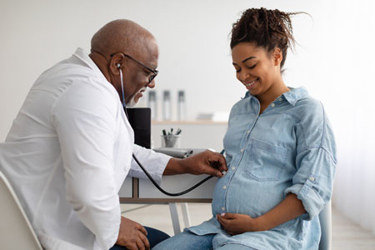 Male doctor examining pregnant woman-GettyImages-1372113926
