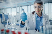 GettyImages-1354172647-scientist-in-lab-with-flasks-pipette