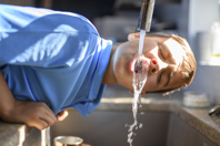 Boy drinking water from faucet-GettyImages-2185736312