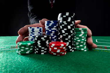 businessman oushing gambling chips-GettyImages-1423256250 businessman oushing gambling chips-GettyImages-1423256250