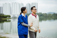 APAC - elderly man helped by home care worker outdoors (high res)