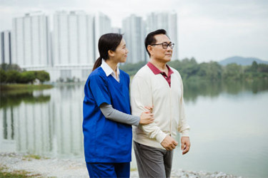 APAC - elderly man helped by home care worker outdoors (high res)