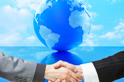 Program Manager Alignment And Integration: Best Practices When Working With A CDMO Handshake in front of globe-GettyImages-154945726