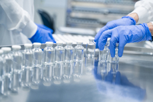 Container Closure Integrity Testing Systems For Drug Manufacturing  GettyImages-2173467866-gloved-hands-vials-conveyor-belt-factory-pharma