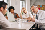 Angry businessman discussing with colleague-GettyImages-1133463611