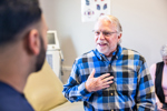 Senior consulting with doctor in exam room-GettyImages-2205398583