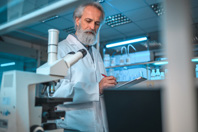 Mature Laboratory Employee Taking Notes-GettyImages-1434121227