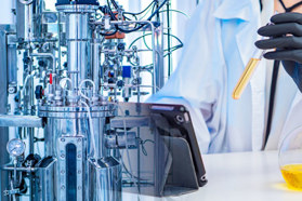 GettyImages-2155418067-bioreactor-scientist-ipad-beaker