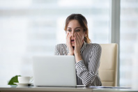 Shocked woman looking at laptop-GettyImages-1073416084
