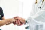 Doctor holding patients hands-GettyImages-474808854