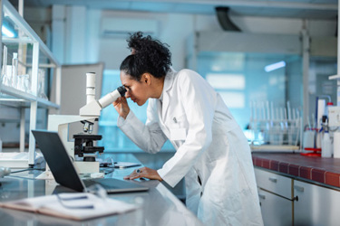 Female scientist microscope-GettyImages-1453524892