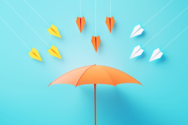 Paper airplanes flying toward umbrella-GettyImages-2136187857