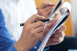 Business people writing on notepad-GettyImages-187524813