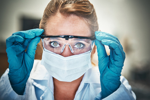 woman scientist with protective goggle and gloves-GettyImages-918825222