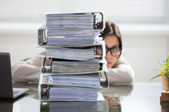 businesswoman hiding behind stack folders-GettyImages-915451280