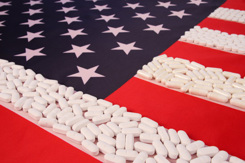 Various Pills on White Stripes of American Flag-GettyImages-172849908