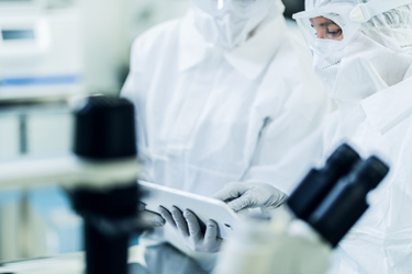 Cleanroom Scientists Using Tablet GettyImages-1341292153
